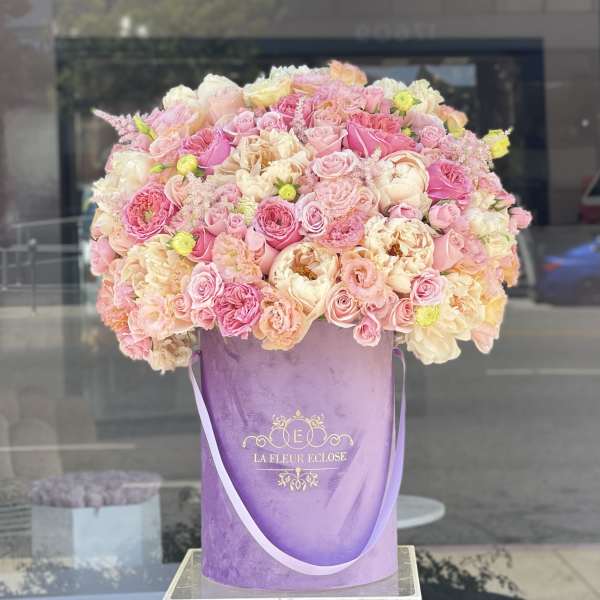 Large pink and cream rose arrangement in a purple hat box