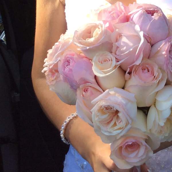 Bride holding a bouquet of pale pink and ivory roses