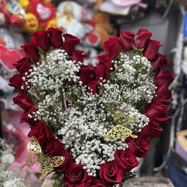 Heart-shaped red rose arrangement with white baby's breath in a black vase