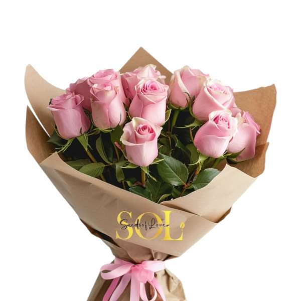 Bouquet of pink roses wrapped in brown paper with a pink ribbon