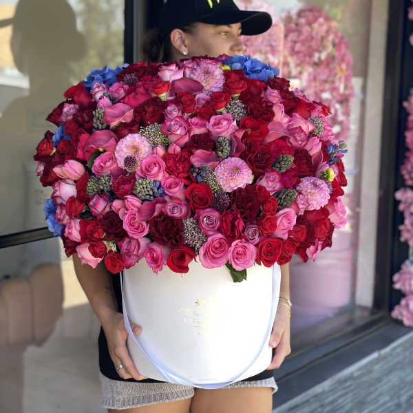 Large bouquet of pink and red roses in a white hat box