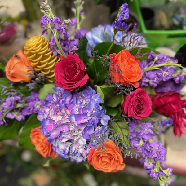 Bouquet of roses, hydrangea, and purple blooms in bright mixed colors