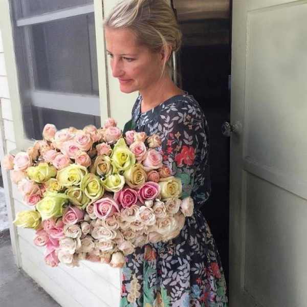 Woman holding a large bouquet of pastel roses