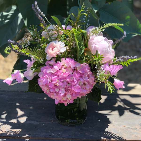 Pink hydrangea and mixed pastel flowers in a glass vase