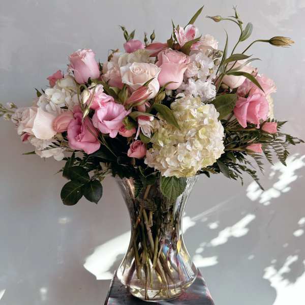 Pink and white flower arrangement in a clear glass vase