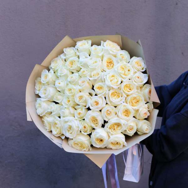 Bouquet of white roses wrapped in tan paper