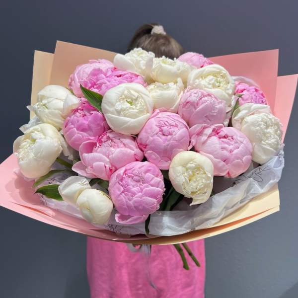 Bouquet of pink and white peonies wrapped in pastel paper