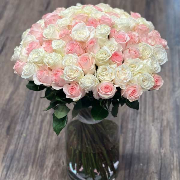 Bouquet of pale pink and white roses in a clear glass vase
