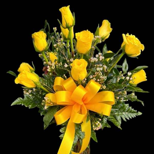 Yellow roses in a glass vase with a large yellow ribbon