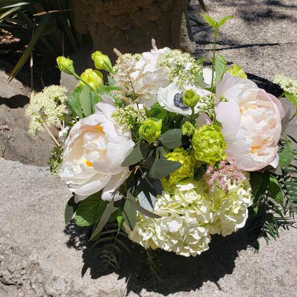 Bouquet of pale pink and white flowers with green accents