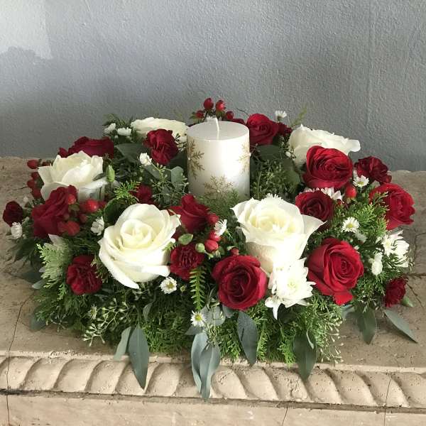 Red and white rose centerpiece with a white pillar candle