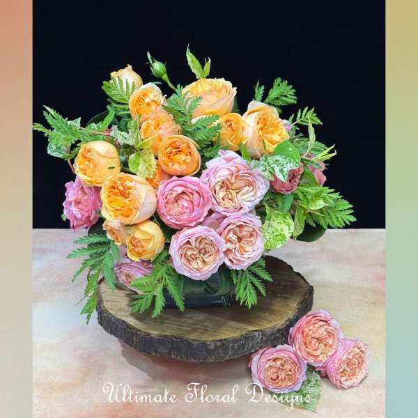Bouquet of peach and pink roses arranged in a low vase