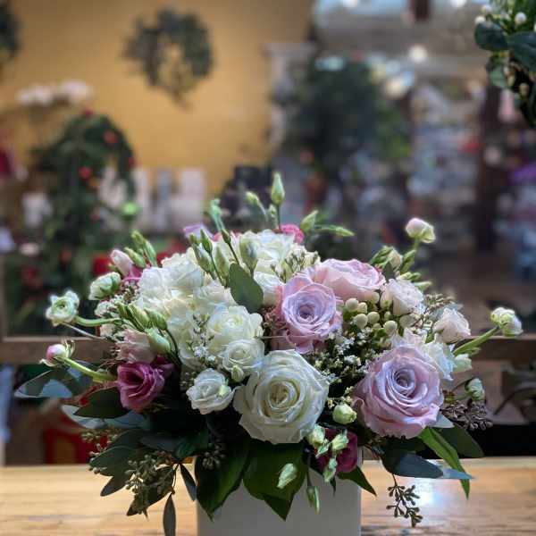 Bouquet of pink and white roses in a white square vase