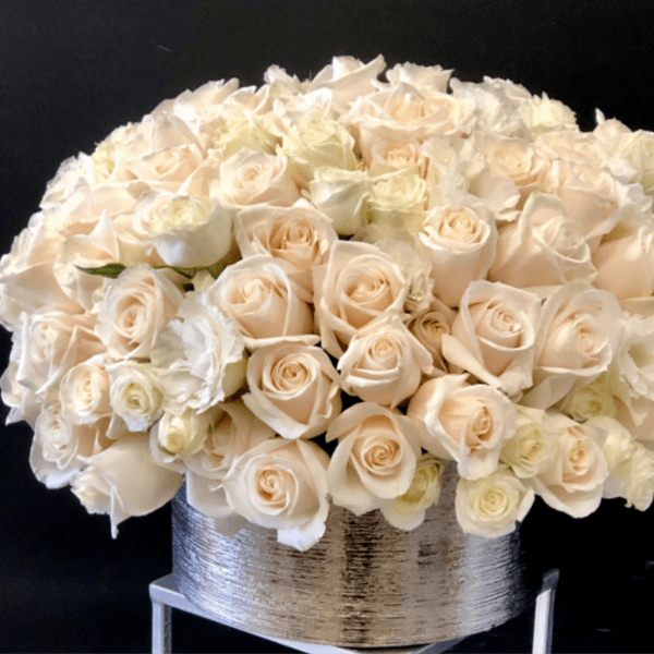 Cream roses arranged in a silver vase