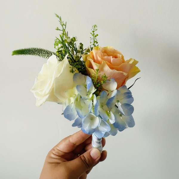 Small bouquet of peach and white roses with blue hydrangea