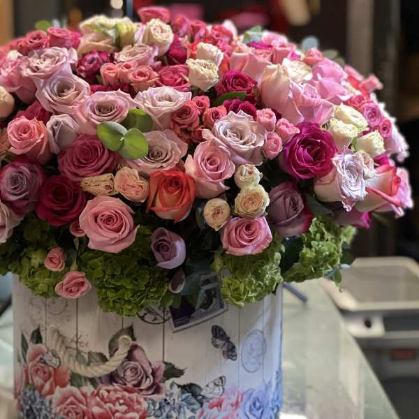 Large bouquet of pink and lavender roses in a decorative box