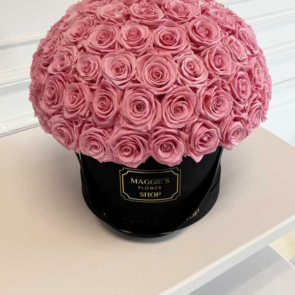 Round bouquet of pink roses in a black hat box