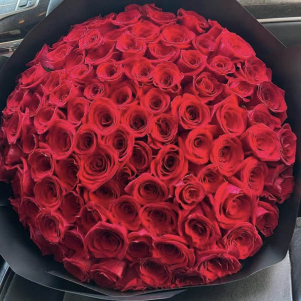 Large bouquet of red roses wrapped in black paper