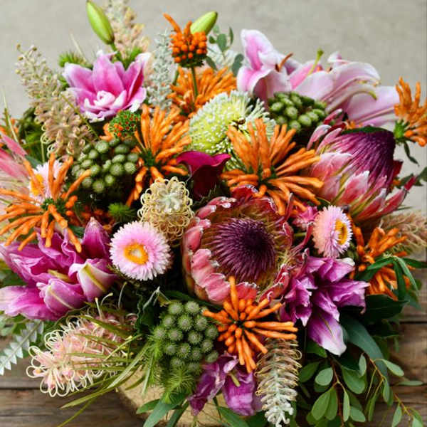 Colorful bouquet with pink lilies, orange blooms, and purple flowers