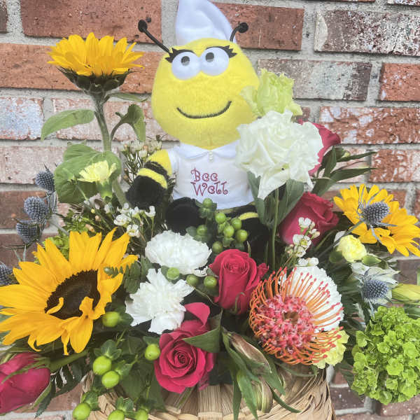 Bouquet with sunflowers and roses around a bee plush toy