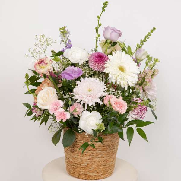 Mixed pastel flower arrangement in a woven basket