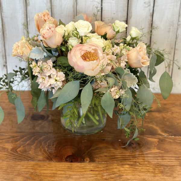 Peach and cream bouquet in a clear glass vase