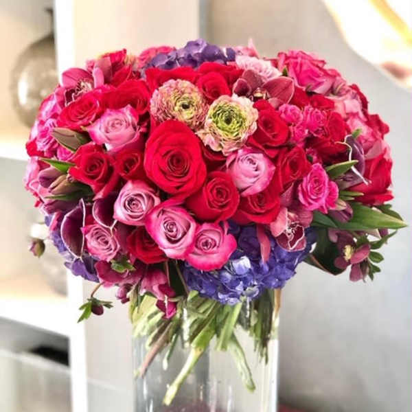 Bouquet of red and pink roses in a clear glass vase