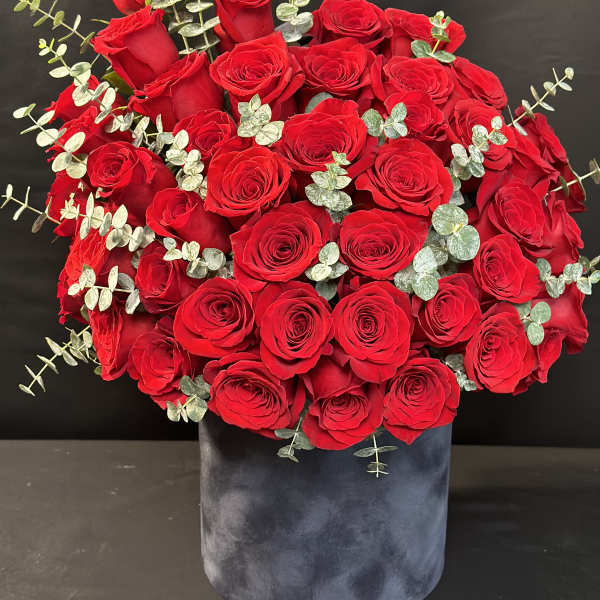 Large bouquet of red roses in a dark velvet box