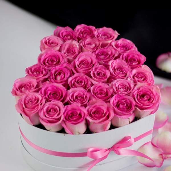 Round box of pink roses with a pink ribbon