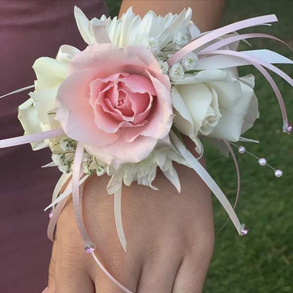Pink and white floral wrist corsage with ribbon streamers