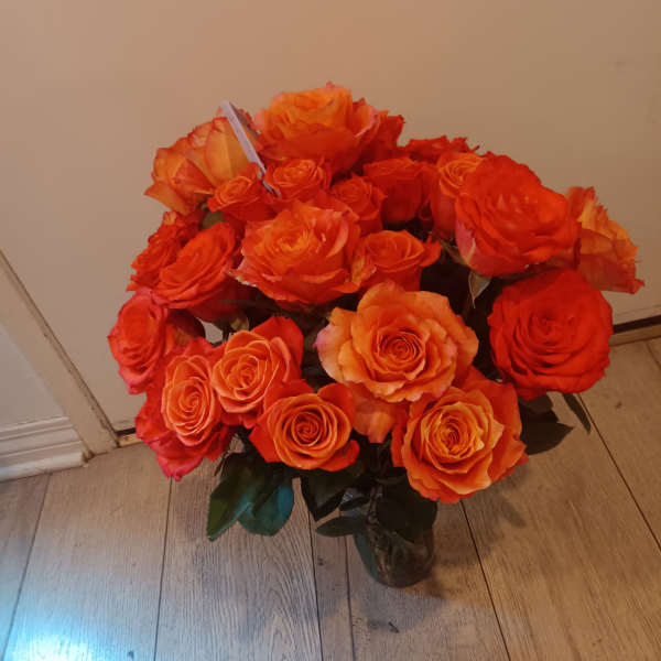Bouquet of orange roses in a glass vase