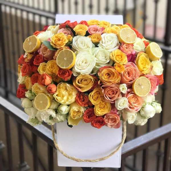 Bouquet of multicolored roses with lemon slices on a white backing