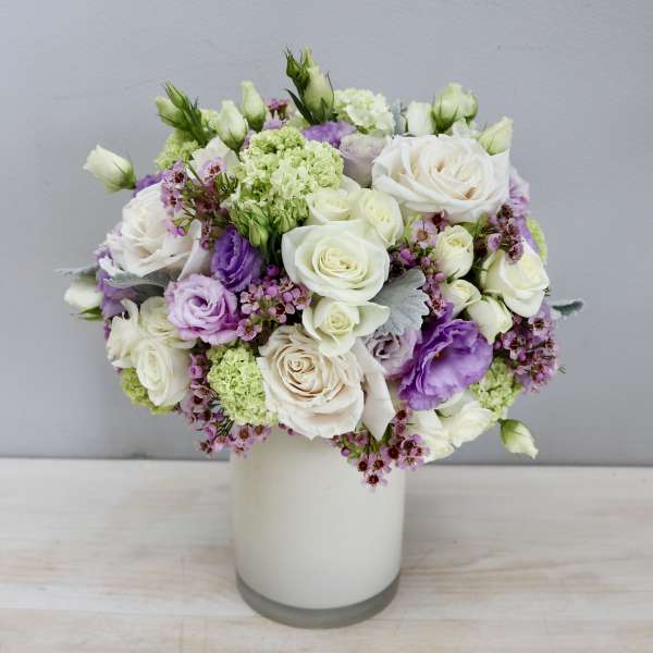 White and lavender rose bouquet in a glass vase