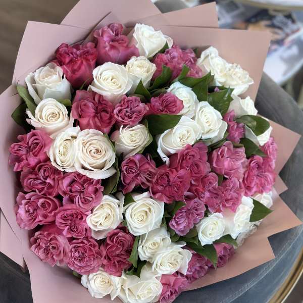 Bouquet of pink and white roses wrapped in blush paper