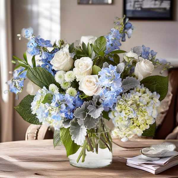 Blue and white floral arrangement in a clear glass vase