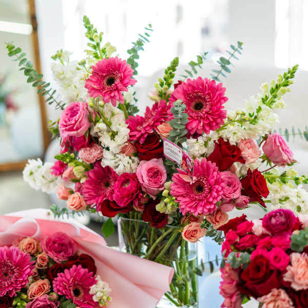Bouquet of pink gerbera daisies and roses in a glass vase
