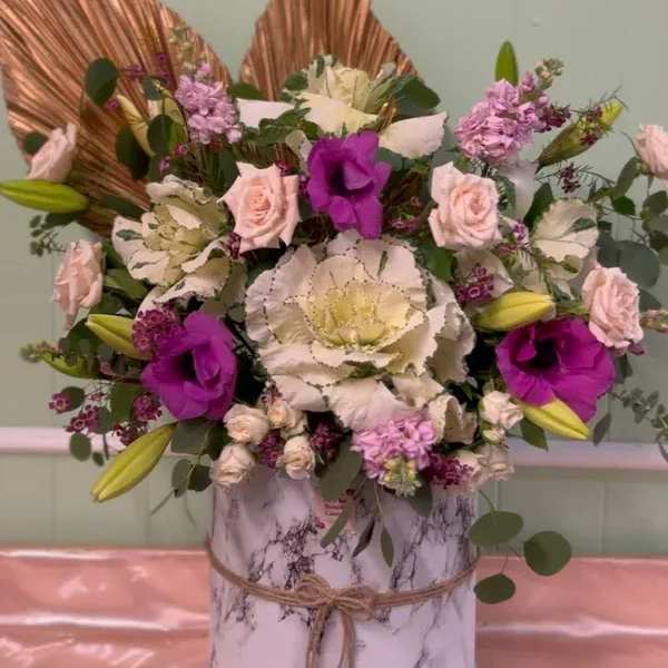 Mixed bouquet with pink and white flowers in a marble-patterned box