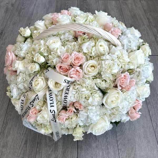 Large round bouquet of white and pale pink roses with hydrangeas and ribbon