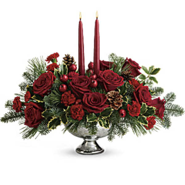 Red rose centerpiece with two lit taper candles in a silver bowl