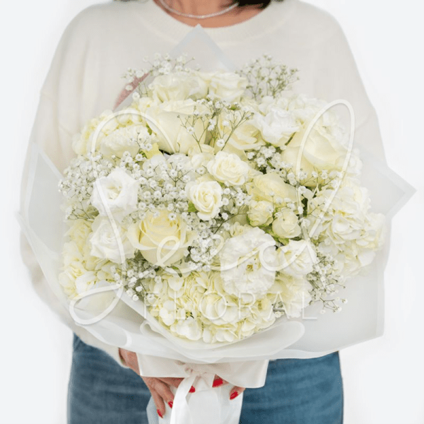 Large hand-tied bouquet of white roses, hydrangeas, and filler flowers wrapped in translucent white paper