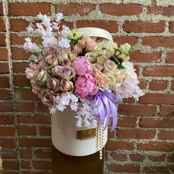 Pastel rose bouquet in a white hat box with a lavender ribbon