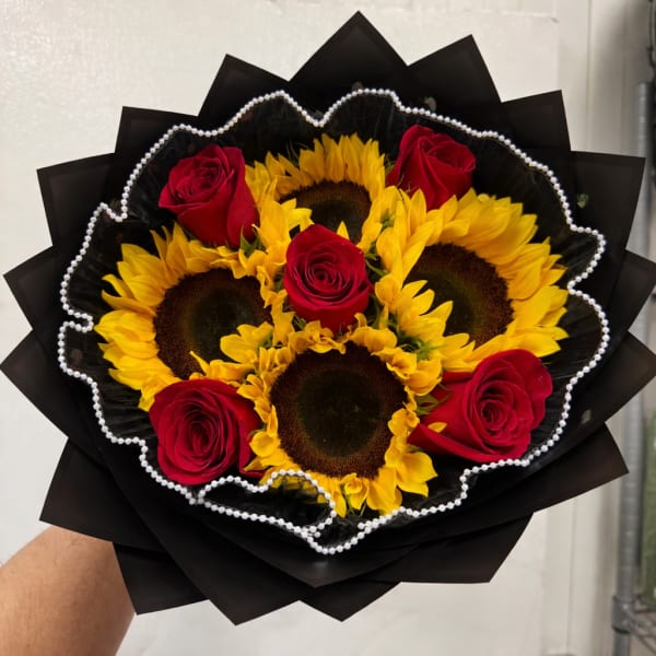 Bouquet of red roses and sunflowers wrapped in black paper