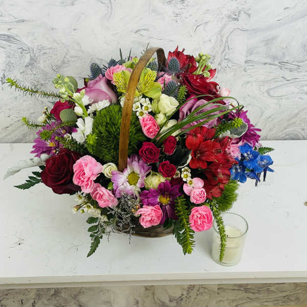 Basket arrangement of mixed pink, red, white, and blue flowers