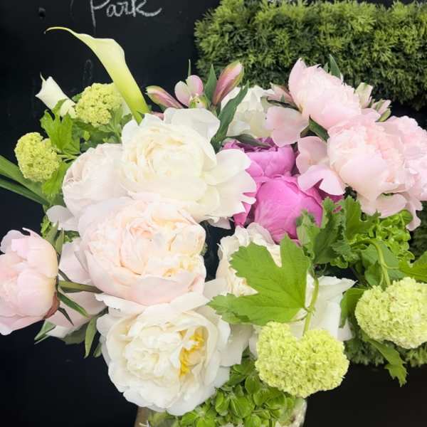 Pink and white peonies with calla lilies in a glass vase