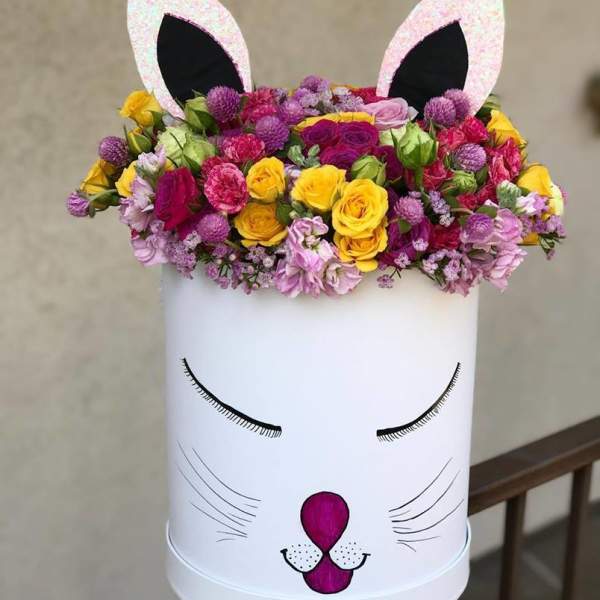 Flower arrangement in a white cat-face box with pink ears