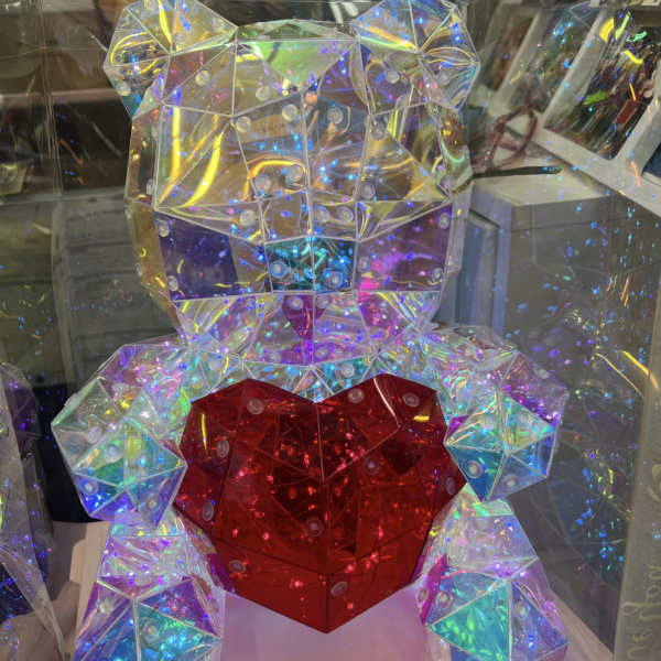 Iridescent geometric teddy bear holding a red heart