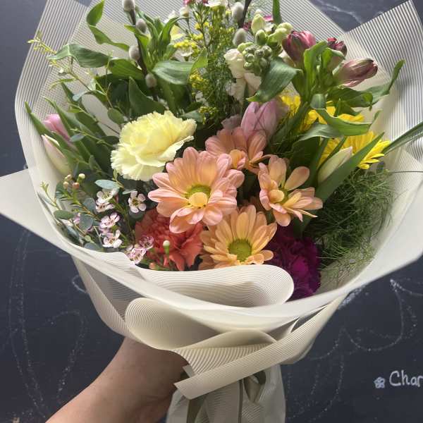 Mixed bouquet with pink and peach daisies, tulips, and pussy willow stems