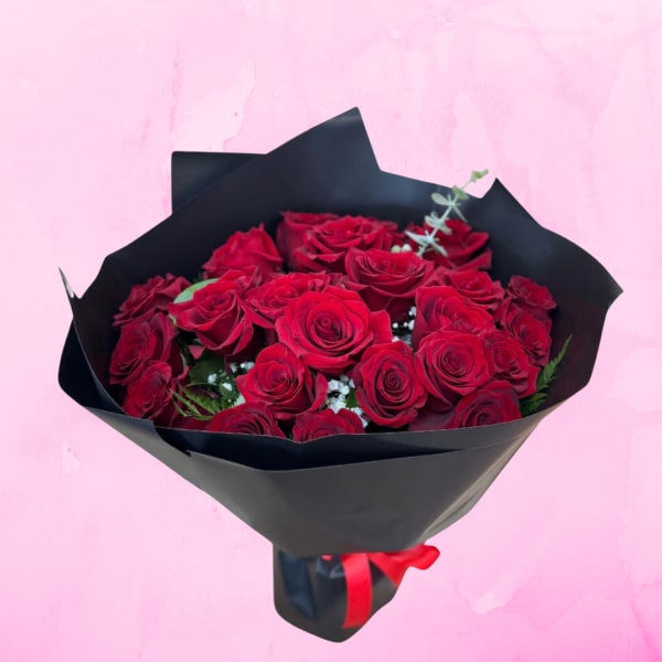 Bouquet of red roses wrapped in black paper with a red ribbon