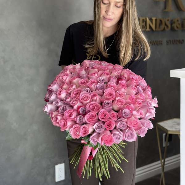 Large bouquet of pink and lavender roses held by a woman