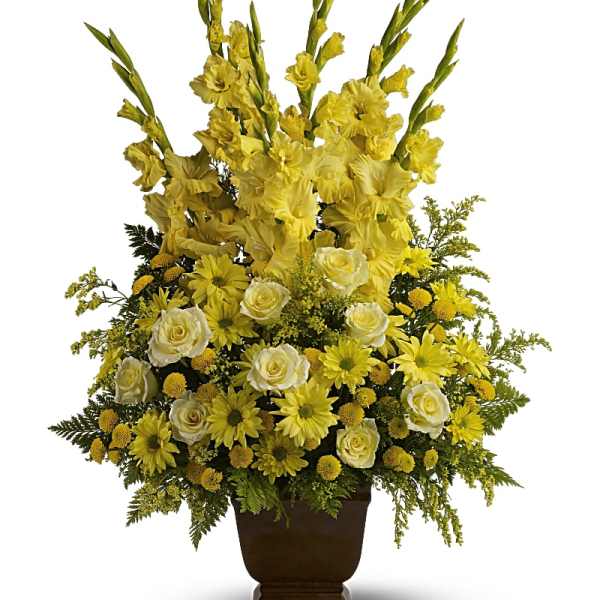Yellow and white floral arrangement in a brown urn vase